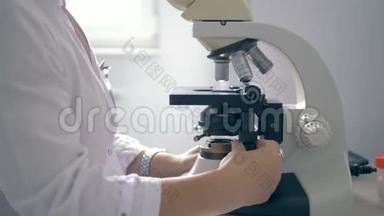 一个用显微镜工作的女人，特写。